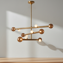 Reese 47.5-inch linear LED chandelier in vintage brass with amber glass shades.